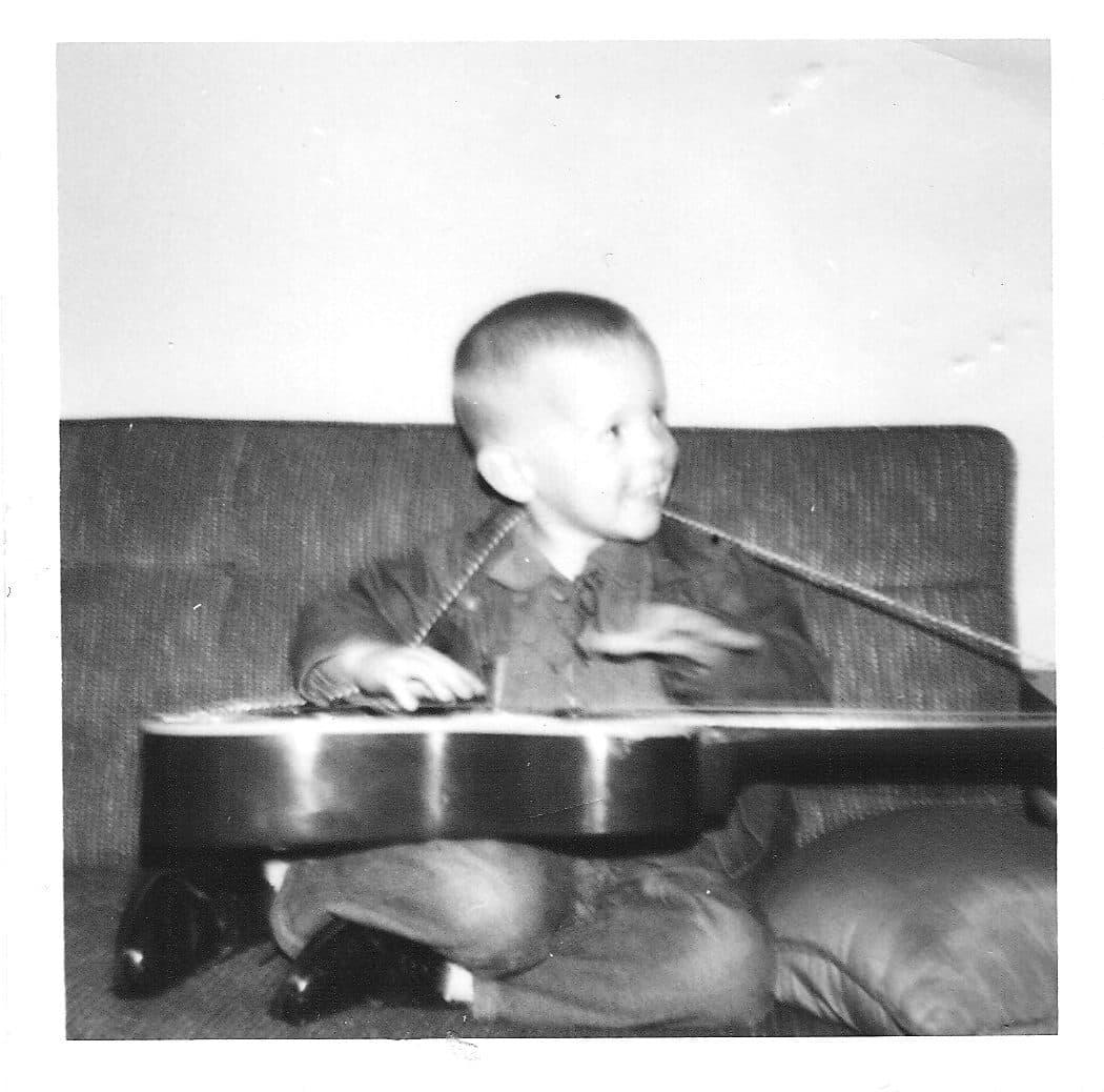Kevin Cadenhead as a child with a guitar